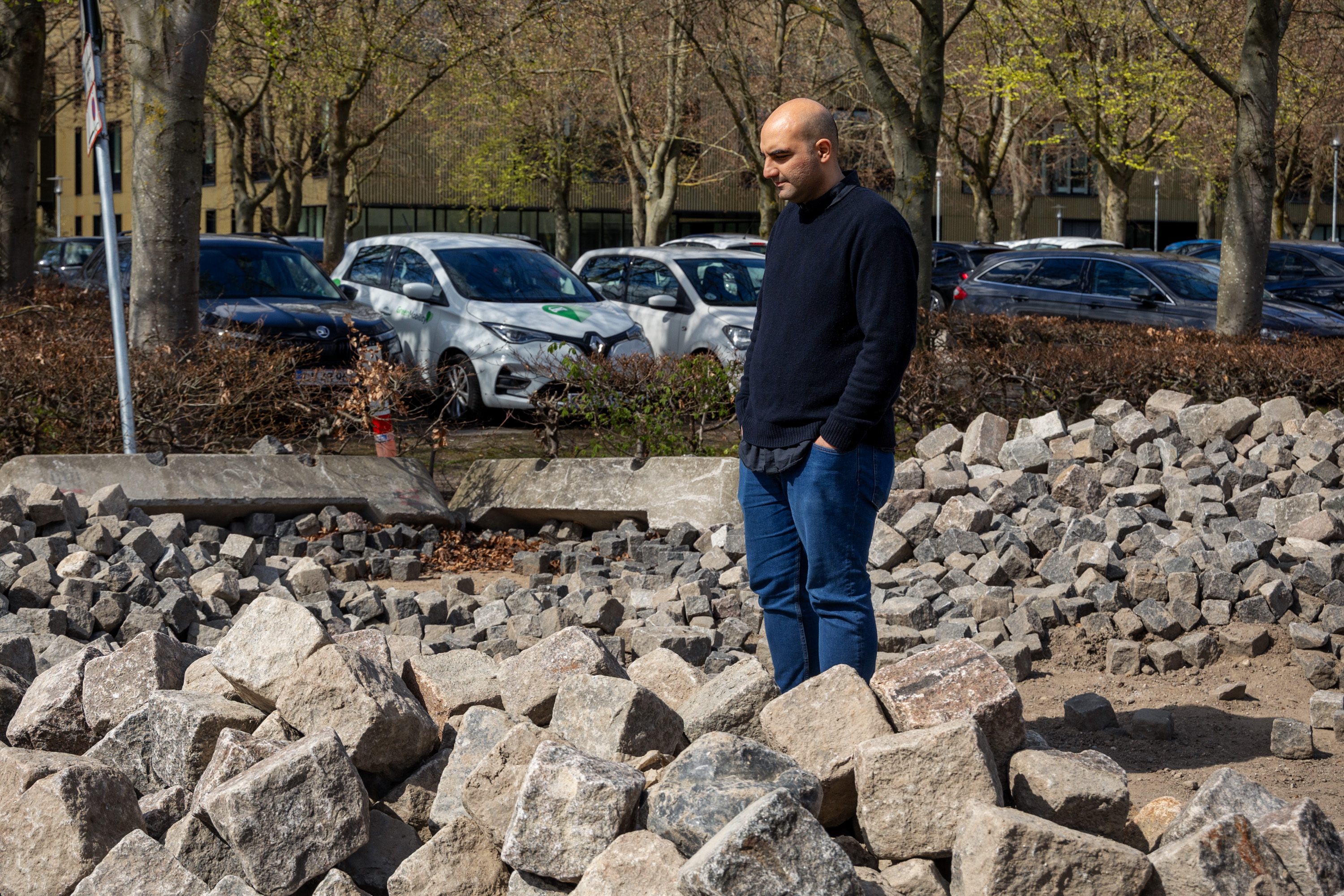 DTU forsker Mohamad Khoshkalam stå ved en bunke af sten på DTU Lyngby Campus.