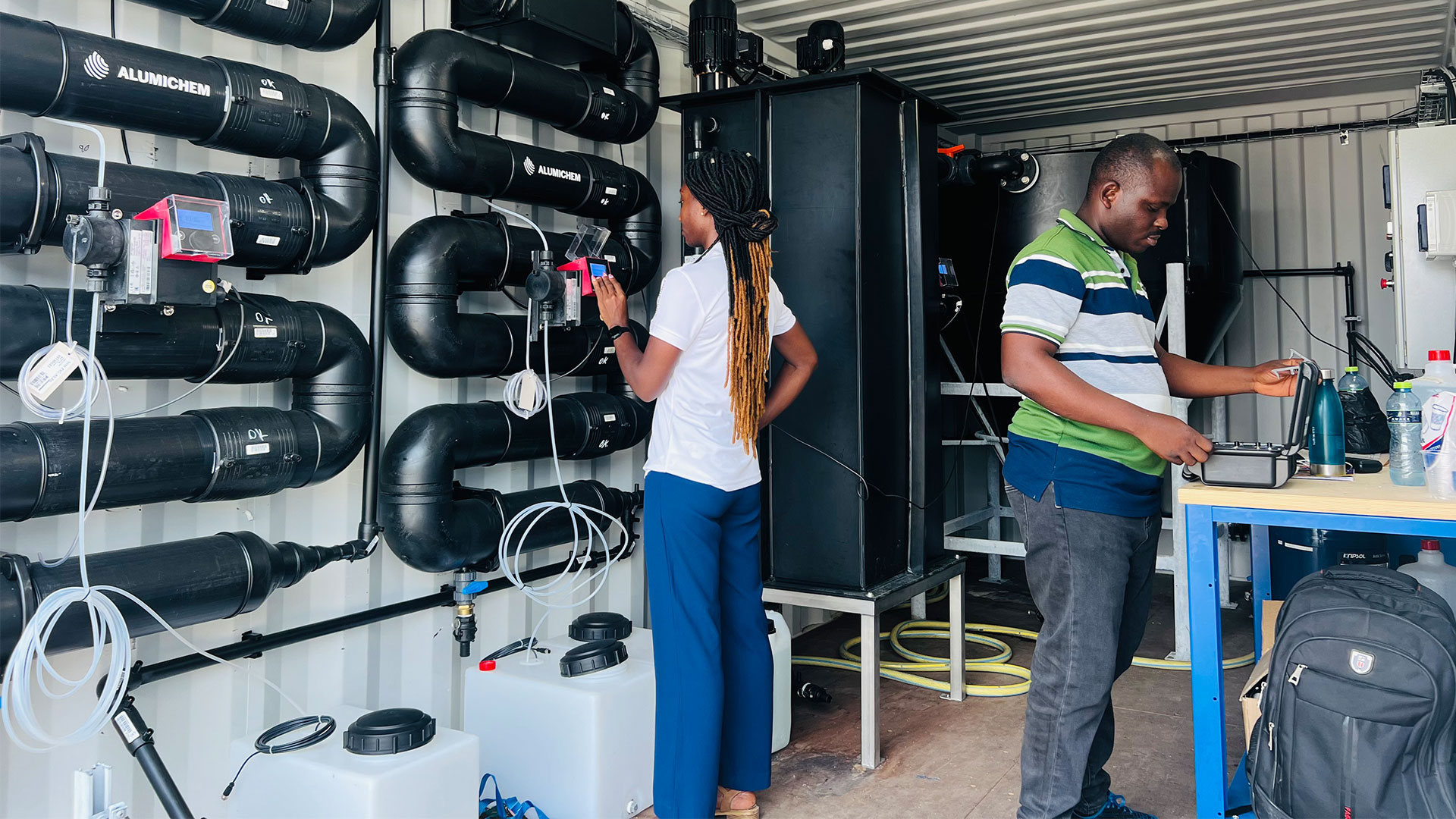 To personer arbejder med teknik til vandrensning. Foto: Isaac Mensah-Boansi