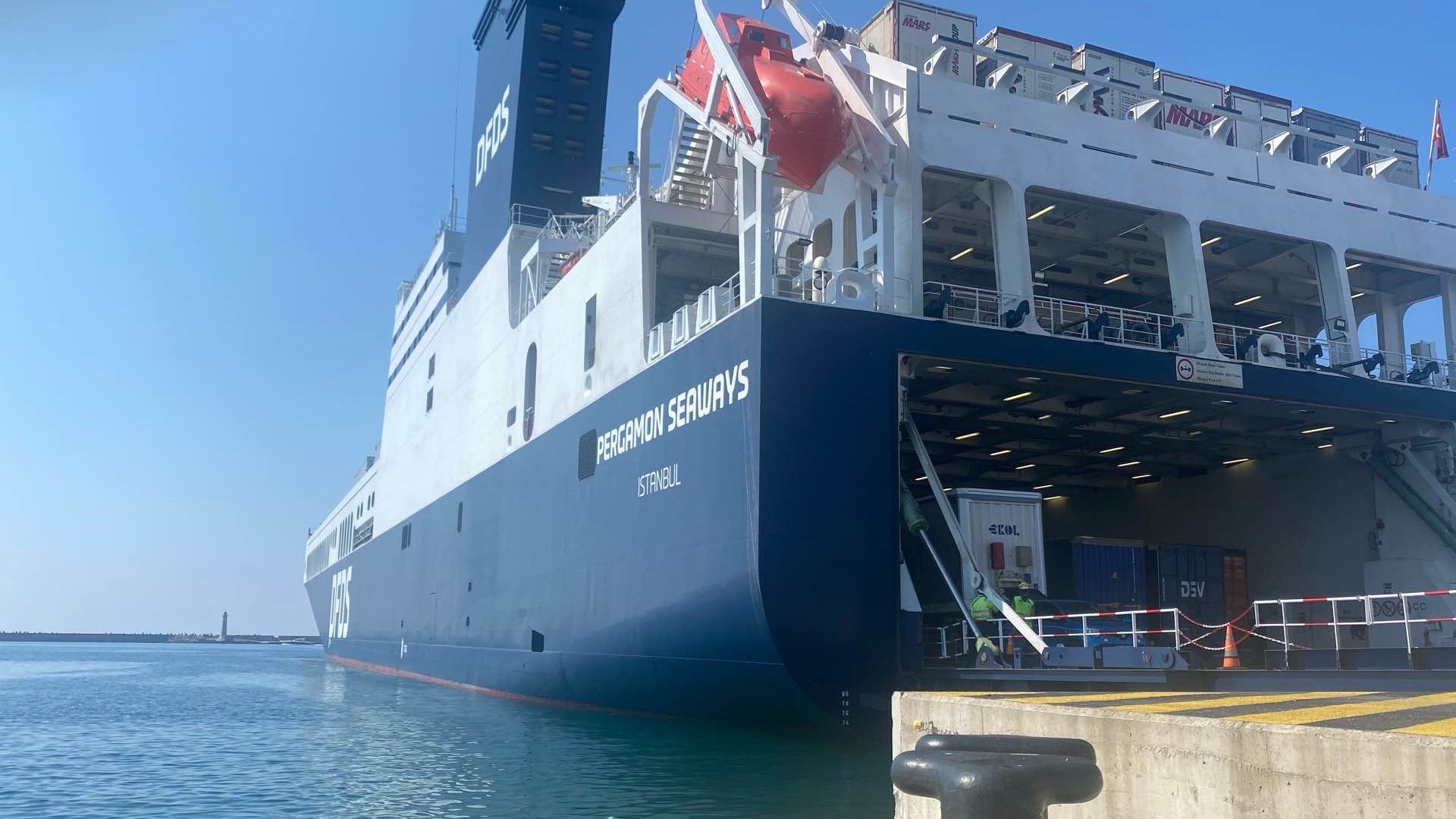 Billede af RoRo-skib, der ligger i havn og er læsset med trailere og containere