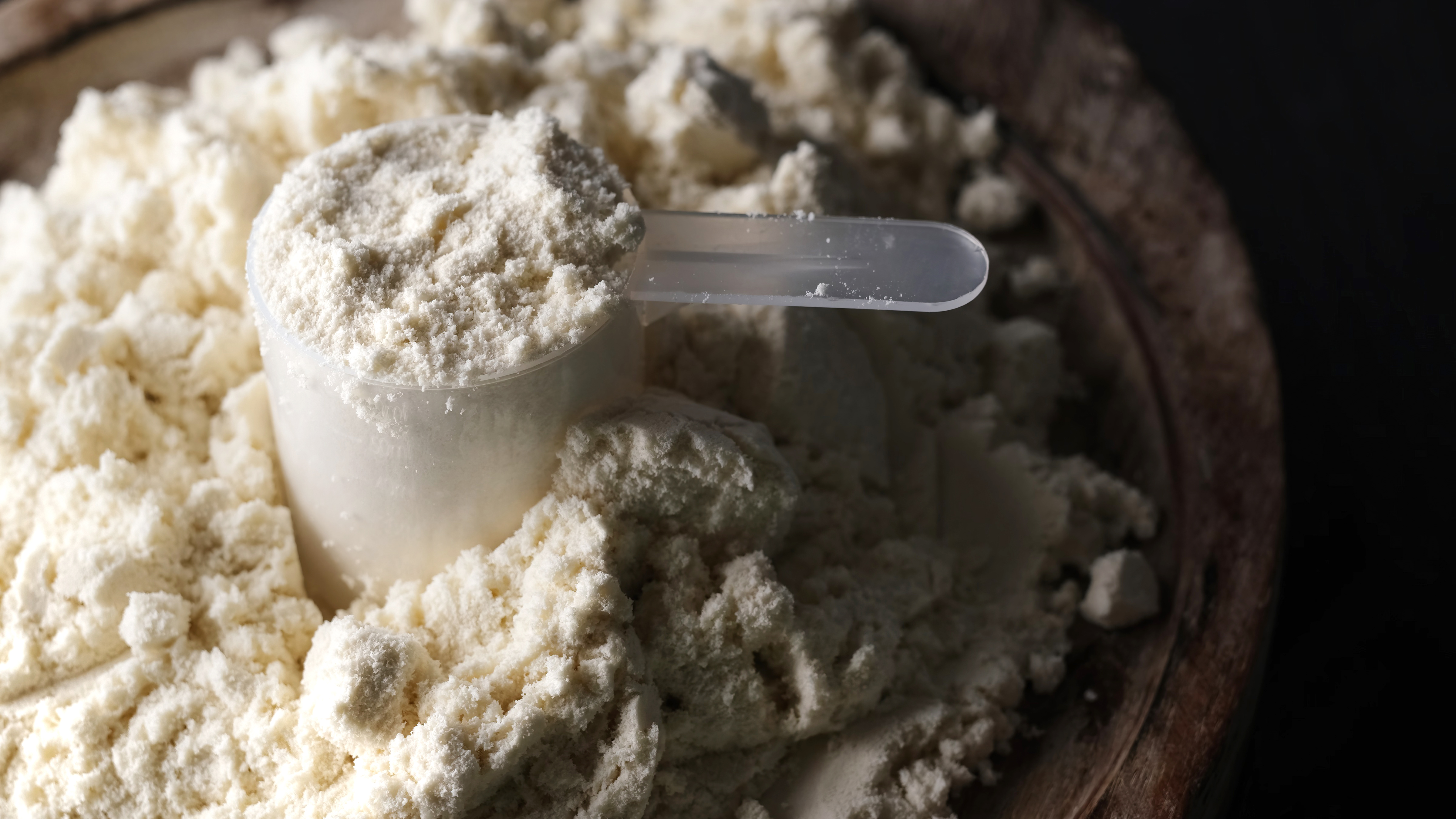 Hvidt proteinpulver med et målebæger