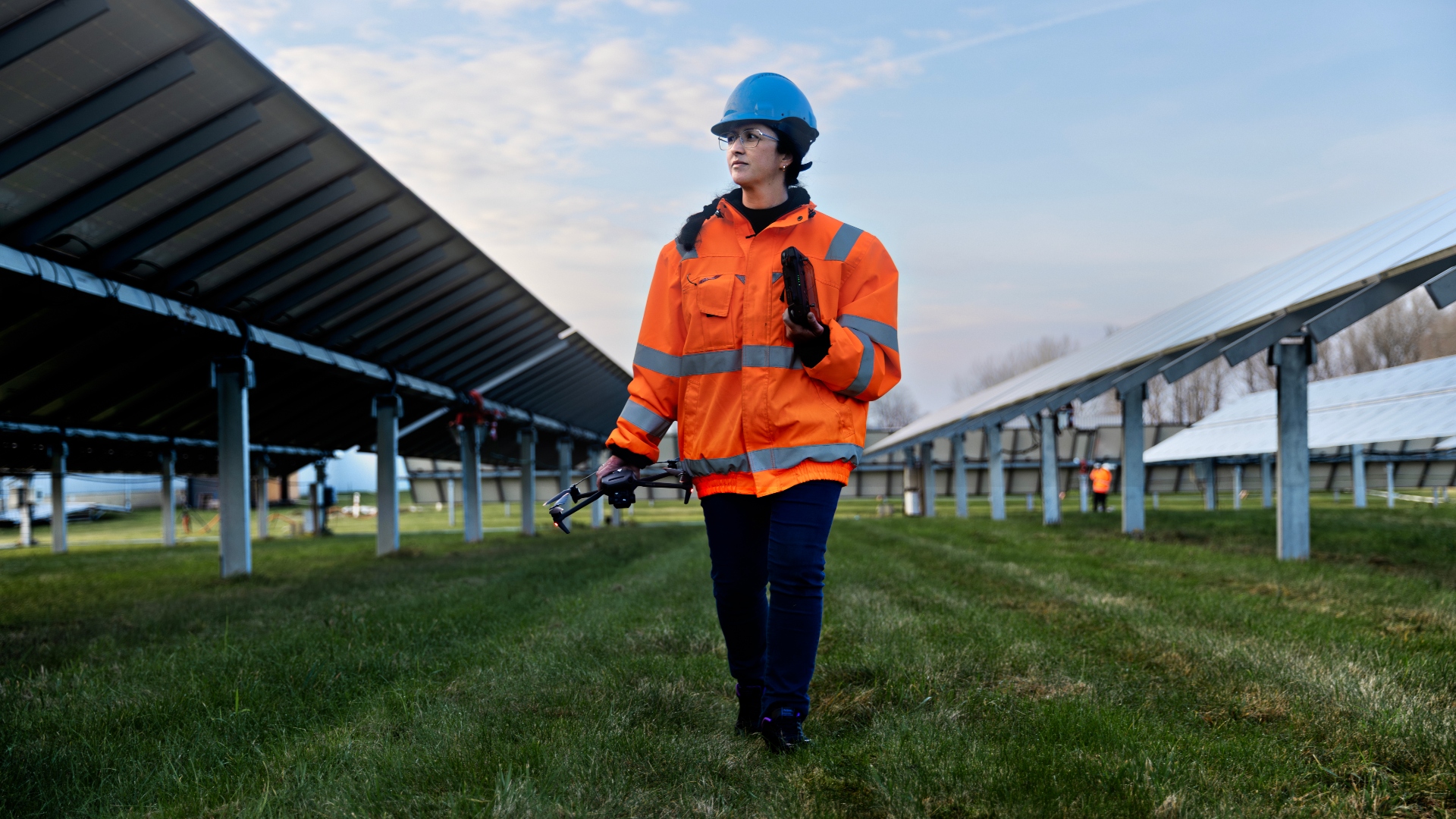Seniorforsker ved DTU Electro Gisele Benatto går med drone gennem solcellepark.