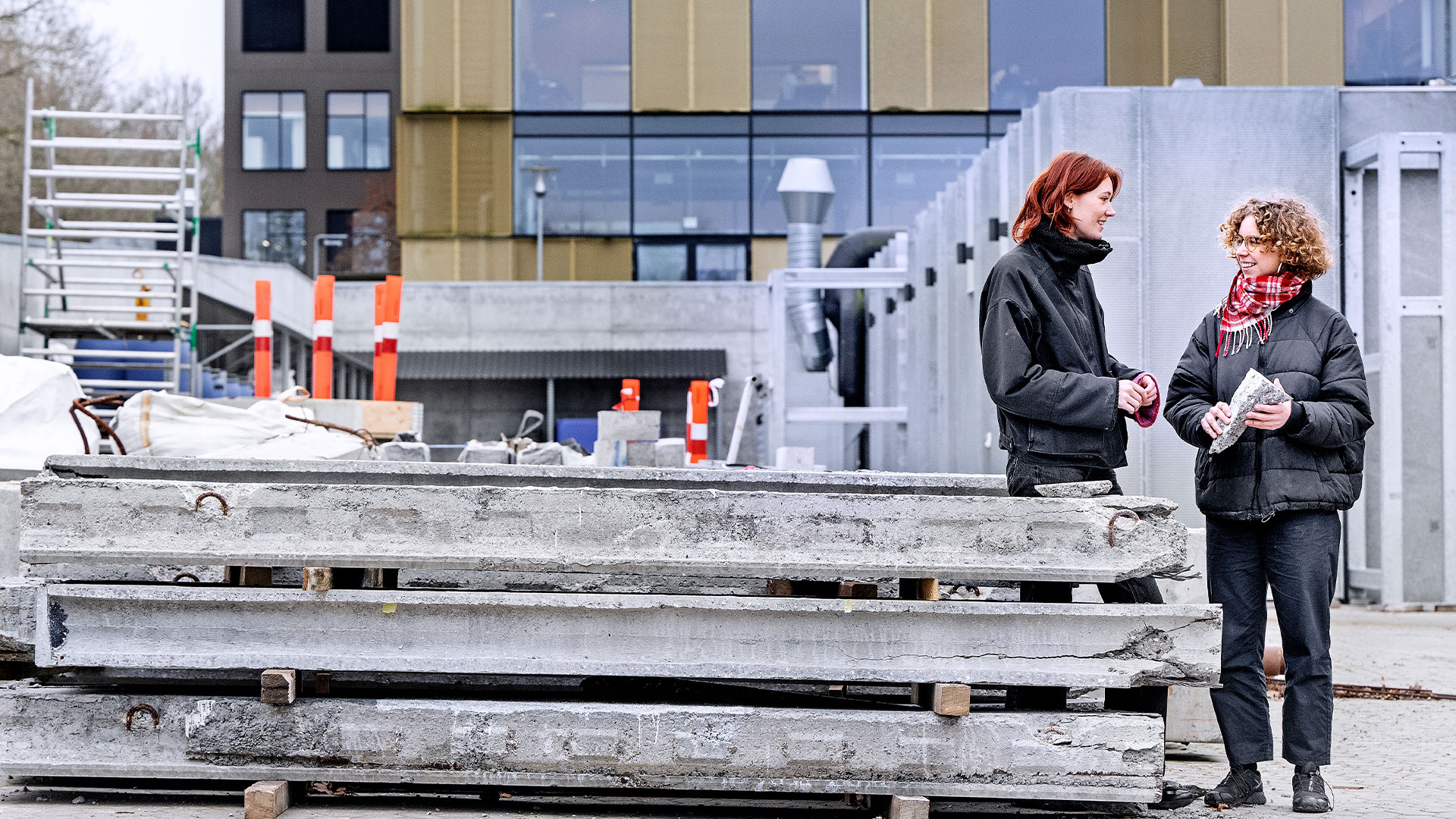 Two women are standing in front of a building by a pile of discarded concrete building supplies. Foto: Bax Lindhardt